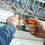 commercial electrical service in sydney-min A commercial electrician switching an electrical actuator using a screwdriver